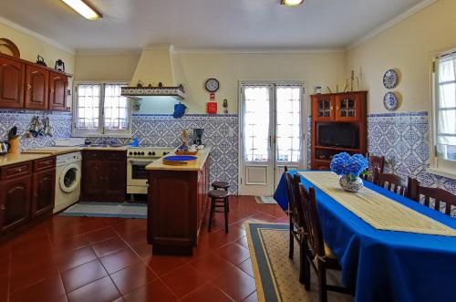 a kitchen with a table with a blue table cloth at Pico do Moinho House in Fajã de Baixo