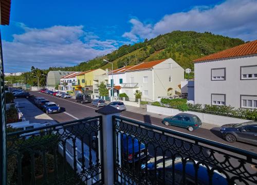 a view of a street with cars parked on the road at Pico do Moinho House in Fajã de Baixo