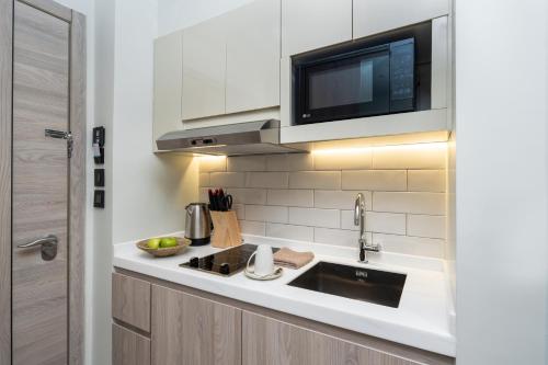 a kitchen with a sink and a microwave at Citadines Abha in Abha