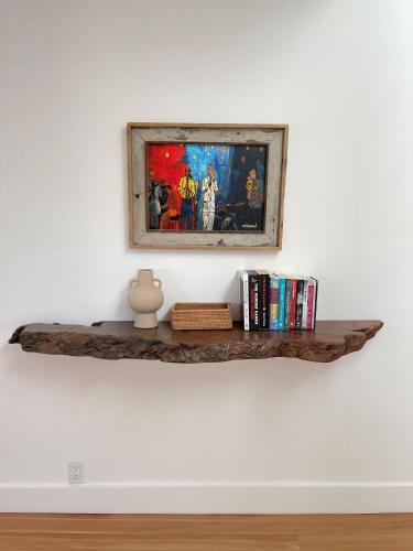 a shelf with a picture on a wall with books at Fitch St Escape A Wine Country Escape in Healdsburg