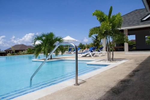einen Pool mit Palmen neben einem Resort in der Unterkunft Vacation Home at The Palms Richmond in Richmond
