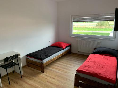 een slaapkamer met 2 bedden, een bureau en een raam bij FUNARENA CHEB 