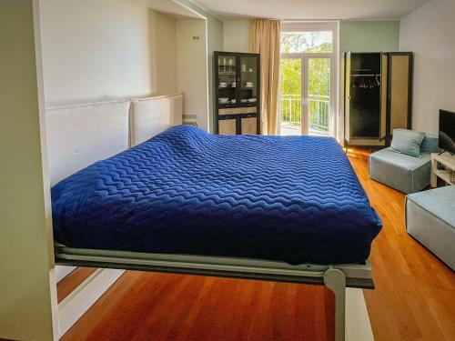 - une chambre avec un grand lit et une couette bleue dans l'établissement Serviced Apartement Xanthurus, à Schwelm