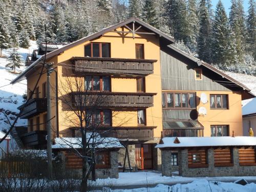 a large wooden house with snow in front of it at Goralturist in Ždiar