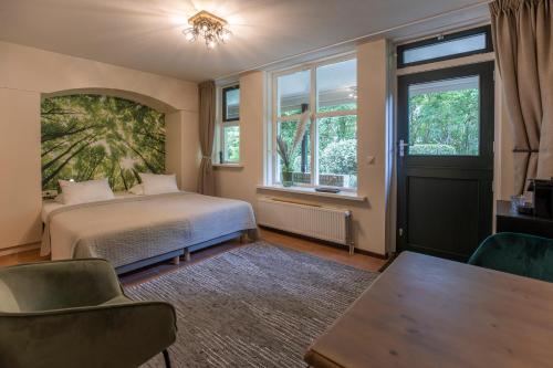 a bedroom with a bed and a table and windows at Bed & Bos de 14 Sterren in Den Burg
