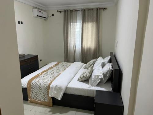 a bedroom with a bed and a window at Swiss Cottage in Kribi