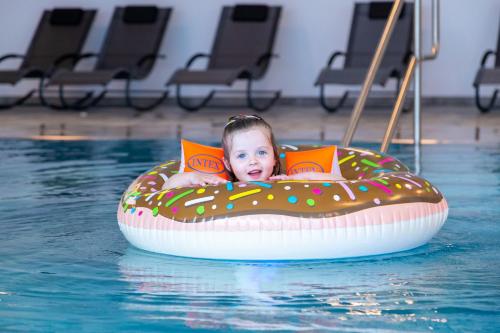 a baby in the water in a swimming pool at Familienhotel Petschnighof in Diex