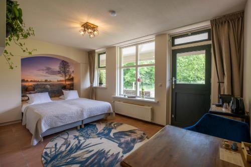 a bedroom with a bed and a table and windows at Bed & Bos de 14 Sterren in Den Burg