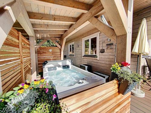 a jacuzzi tub on the deck of a house at Chalets zum Latschen in Mauth