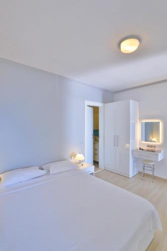 a white bedroom with a bed and a desk at James Pansiyon Blue sea view villas Kaş Peninsula in Kas