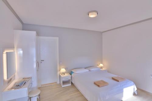 a white bedroom with a white bed and two tables at James Pansiyon Blue sea view villas Kaş Peninsula in Kas