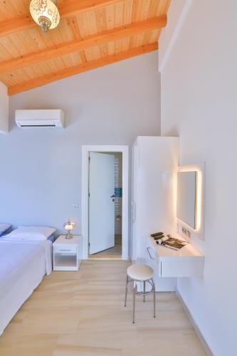 a bedroom with a bed and a desk with a computer at James Pansiyon Blue sea view villas Kaş Peninsula in Kas