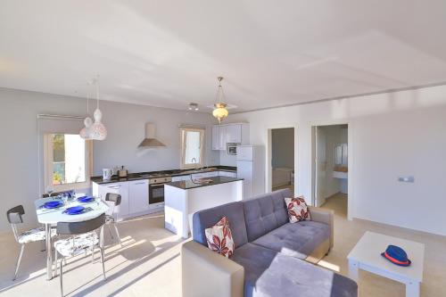 a living room with a blue couch and a kitchen at James Pansiyon Blue sea view villas Kaş Peninsula in Kas