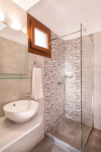 een badkamer met een wastafel en een glazen douche bij Green Studio in Kantouni in Kokkari