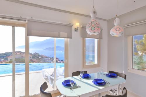 a dining room with a white table and chairs and a large window at James Pansiyon Blue sea view villas Kaş Peninsula in Kas