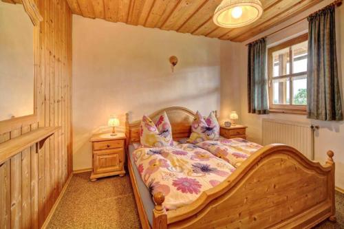 ein Schlafzimmer mit einem Holzbett in einem Zimmer in der Unterkunft Bayerwald-Ferienhof Schmid in Eppenschlag