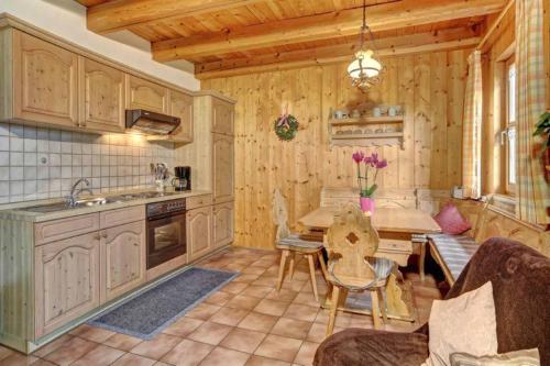 uma cozinha com armários de madeira, uma mesa e uma sala de jantar em Bayerwald-Ferienhof Schmid em Eppenschlag