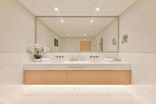 a bathroom with two sinks and a large mirror at Ultra Luxury Palm Tower with Shared Hotel Facilities in Dubai
