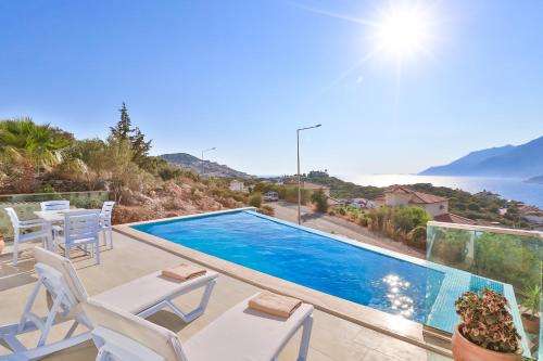 a swimming pool with chairs and a view of the ocean at James Pansiyon Blue sea view villas Kaş Peninsula in Kas