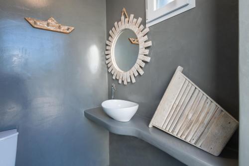 a bathroom with a sink and a mirror on a wall at Zoe & Zen Collection in Kampos Paros