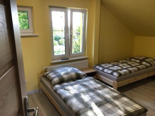 a small room with two beds and a window at GOLENICKA PRZYSTAŃ in Golenice