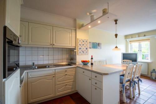 a kitchen with white cabinets and a counter top at Hardesweg 63 Nummer 2 in Wrixum