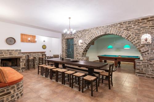 a dining room with a brick wall and a ping pong table at Zoe & Zen Collection in Kampos Paros