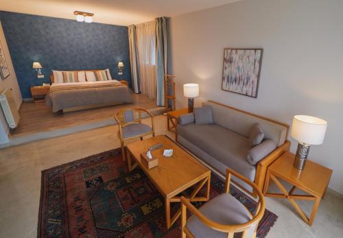 فندق كازا دور في بيروت: غرفة معيشة مع أريكة وسرير