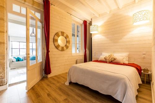 una camera con un letto in una stanza con pareti in legno di Demeure en pierre avec Piscine a Vertheuil-en-Médoc