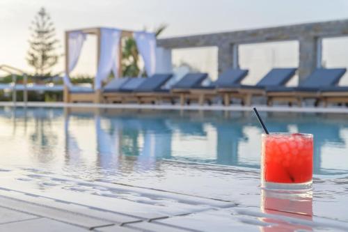 a drink sitting on a table next to a swimming pool at Zoe & Zen Collection in Kampos Paros