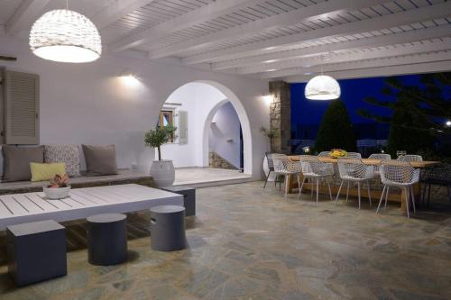 a dining room with a table and chairs and lights at Zoe & Zen Collection in Kampos Paros