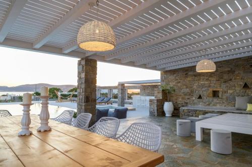 a patio with a table and chairs and a stone wall at Zoe & Zen Collection in Kampos Paros