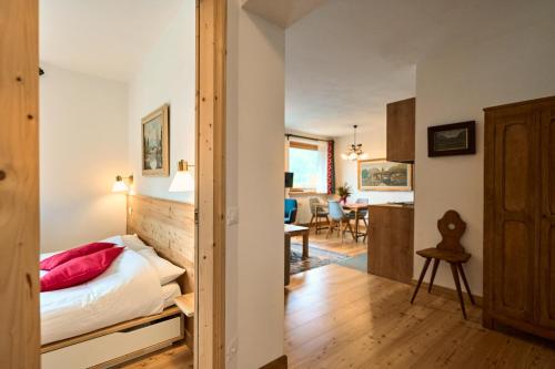 a bedroom with a bed and a dining room at Casa al Sole Apt. 2 in Pinzolo