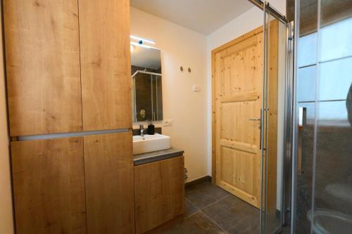 La salle de bains est pourvue d'un lavabo et d'une douche. dans l'établissement Casa al Sole Apt. 2, à Pinzolo