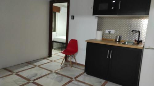 a kitchen with a red chair in a room at Convenient Rooms - Ferry, Train & Bus Station - in Algeciras