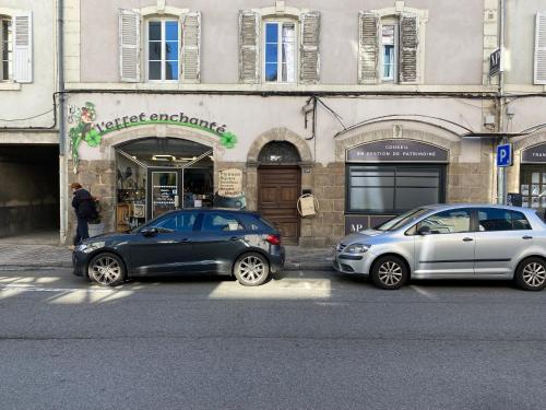 two cars parked in front of a building at L'Escale ZEN in Tulle