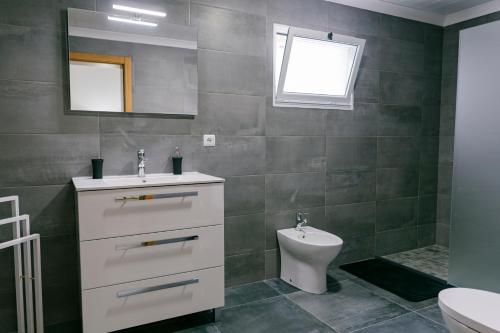 a bathroom with a sink and a toilet at Village House in Ribeira Grande