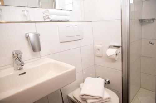 a white bathroom with a sink and a toilet at Hotel Dietmayr in Neumarkt in der Oberpfalz