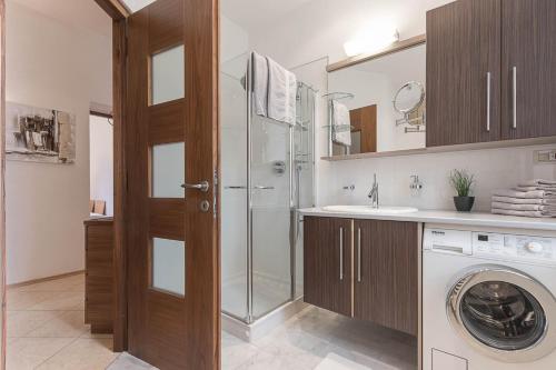 y baño con ducha y lavadora. en Appartment Lissi, en Merano