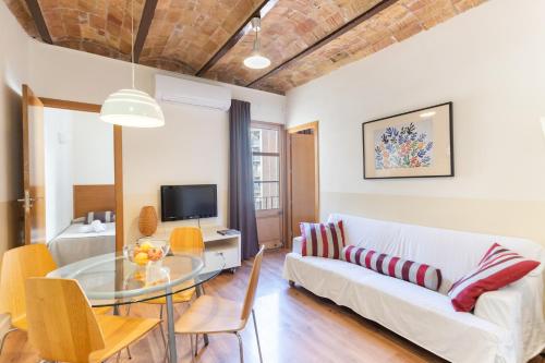 salon z białą kanapą i szklanym stołem w obiekcie Atica Apartments - by Weflating w Barcelonie