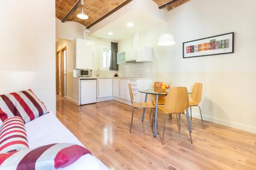 a kitchen and dining room with a table and chairs at Atica Apartments - by Weflating in Barcelona