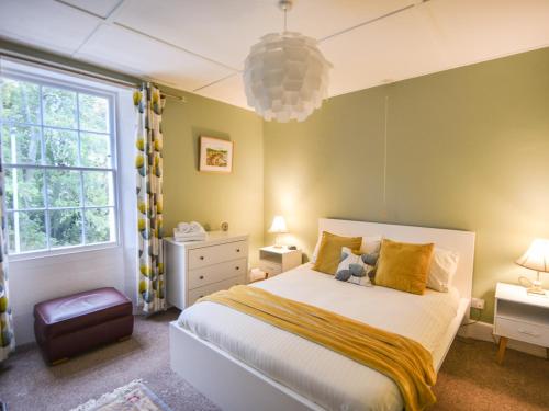 1 dormitorio con 1 cama blanca grande con almohadas amarillas en Flat 3, St Agnes House, en Lyme Regis