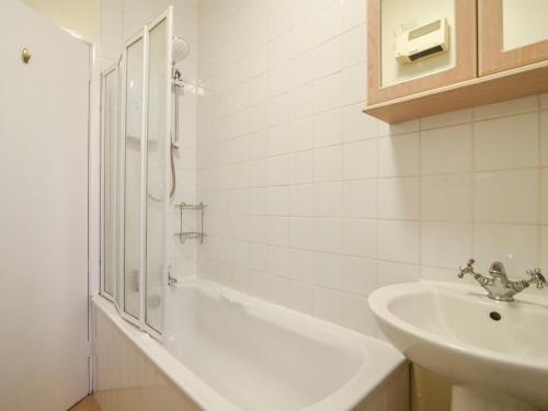 a bathroom with a sink and a shower and a tub at Flat 3, St Agnes House in Lyme Regis