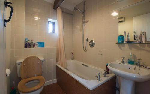 a bathroom with a toilet and a sink and a tub at The Old Cart Shed in the Peak District in Bakewell