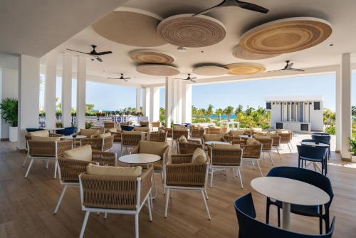 a restaurant with tables and chairs with a view at Riu Latino - Adults Only - All Inclusive in Costa Mujeres