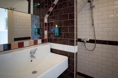 a bathroom with a white sink and a mirror at Bed & Bos de 14 Sterren in Den Burg