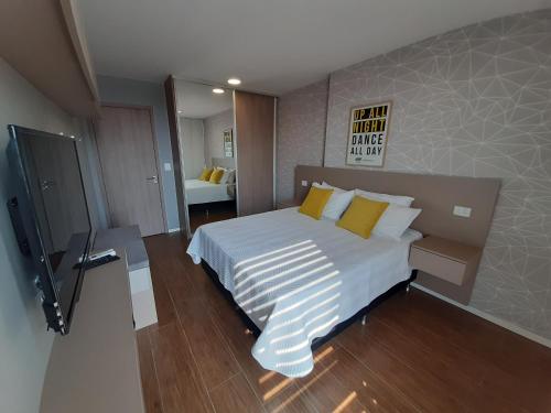 sypialnia z dużym białym łóżkiem z żółtymi poduszkami w obiekcie You Suite by INN w mieście Santa Cruz de la Sierra