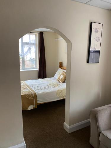 a bedroom with a bed and an archway with a window at Clarendon Lodge - accommodation only in Skegness