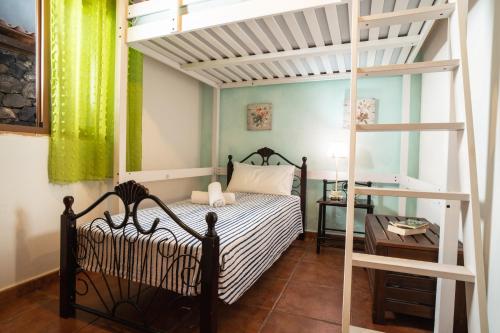 ein Schlafzimmer mit einem Etagenbett und einer Leiter in der Unterkunft Terraza del Atlántico in Playa de Santiago