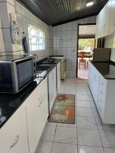 a kitchen with a microwave and a counter top at Sítio Chalako, casa exclusiva às margens do Rio Mimoso in Bonito